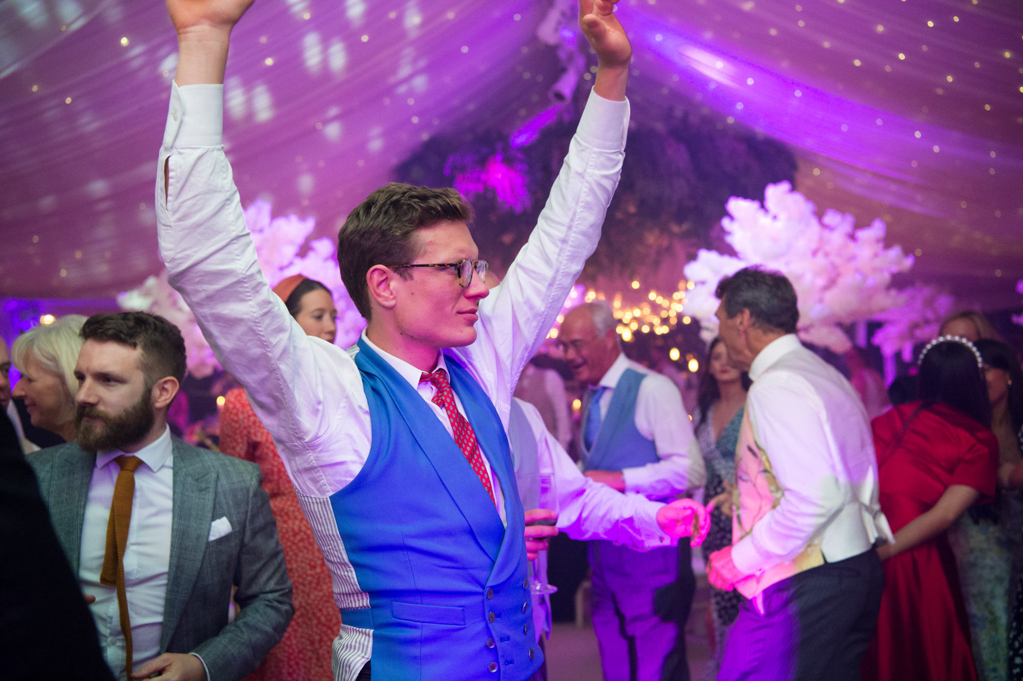 Wedding guests dancing with their arms in the air